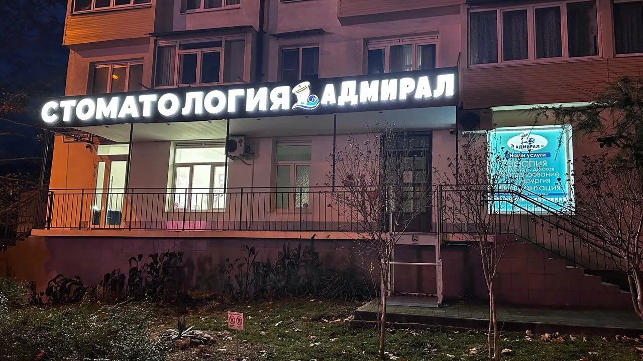Вывеска «Стоматология Адмирал» вечером